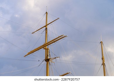  Ship mast. Folded sails. Background of the evening sky.