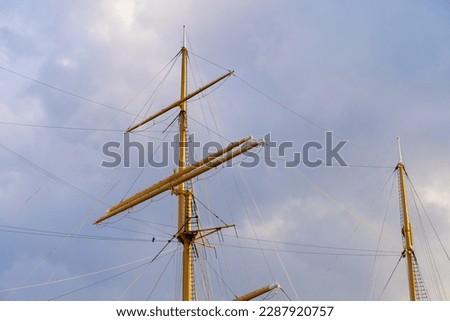  Ship mast. Folded sails. Background of the evening sky.