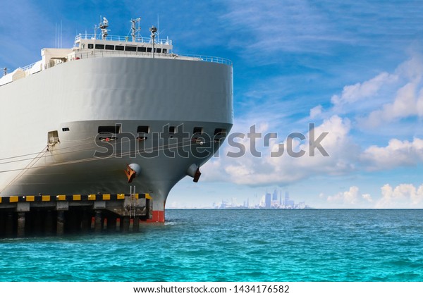 Ship in  port export and business\
logistic closeup front of ship view, Auto car carrier ship,\
designed for transportation of cars on blue sky\
background.