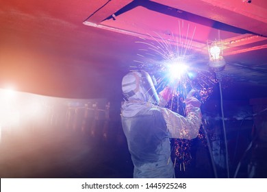 Ship Repair Industrial Worker Welding Close Up Spark Light For Ship Repair Overhead Position Welding In Shipyard Under Water Ballast Tank.