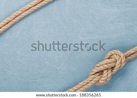 Ship rope knot on blue wooden texture background