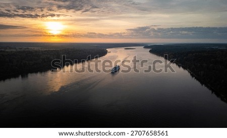 a ship sails down the river at dawn
