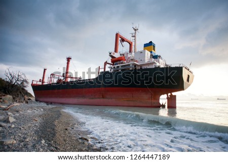 Ship is at the sea shore. Dramatic sky with clouds