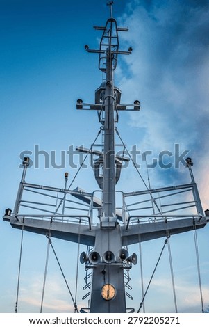 Ship structures, masts, antennas, funnel, ship wheelhouse against the blue sky and clouds. Vessel traveling at ocean.