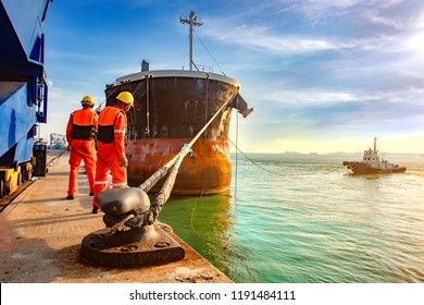 ship vessel is on leaving departure from the port terminal after completion of loading/discharging operation by gang of mooring attending at last party, tug boat standing by to safety assist towage - Powered by Shutterstock