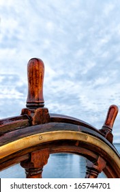 Ship Wheel Made Of Wood And Brass. Close Up Detail On A Sailboat At Sea. Copy Space. Concept For Leadership, Responsibility, Steering, Leading, Guiding, In Charge 