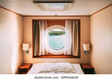 Ship Window In Craft Cabin With Bed. View On Sea. Luxury Cabin On Ferry Boat Or Cruise Liner. Sea Cruise Vacation Trip Travel Concept.