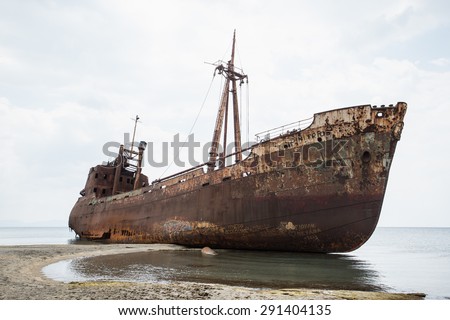 Ship wreck surrounded by sea waves on moody Selinitsa beach, Gytheio, Greece