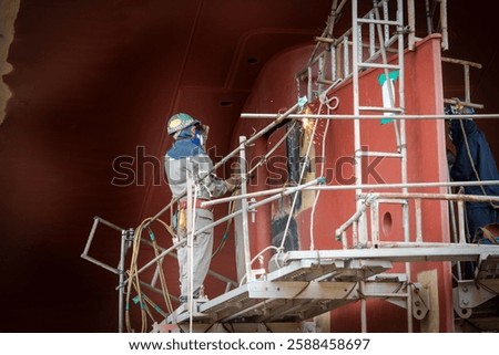 A ship yard worker is working on a ship propeller during dry docking.