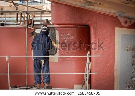 A ship yard worker is working on a ship propeller during dry docking.