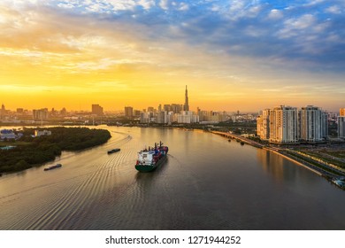 Shipping cargo to harbor by ship, aerial view. Center Ho Chi Minh City, Vietnam with development buildings, transportation, energy power infrastructure, view from Saigon river