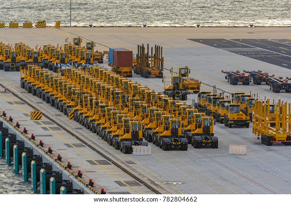 Shipping container\
trucks and trailers lined up on commercial cargo port, waiting to\
be dispatch and\
shipped.