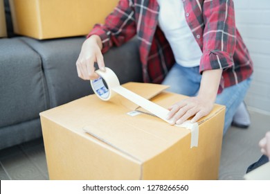 Shipping shopping online ,young start up small business owner writing address on cardboard box at workplace.small business entrepreneur SME or freelance asian woman working with box at home