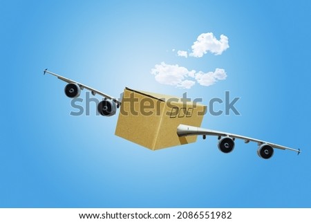 Shipping or travel concept - cardboard box with jet airplane wings and engines in the sky