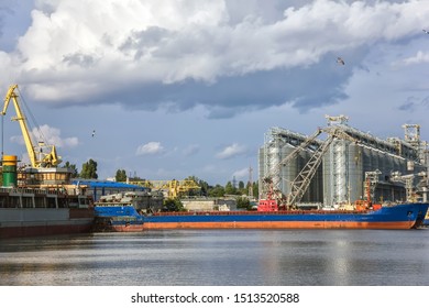 ships for grain transportation and port cranes for loading.River port terminal. Transportation of agricultural products. Soft focus- Image