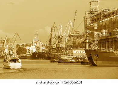 ships for grain transportation and port cranes for loading.River port terminal. Transportation of agricultural products. Soft focus