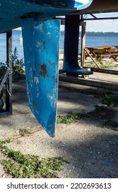 A Ship's Rudder Under The Ship On The Shore Of The Harbor