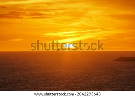 ships sailing on the horizon with sunset