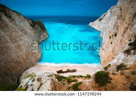 Shipwreck in Navagio beach. Azure turquoise sea water and paradise sandy beach. Famous tourist visiting landmark on Zakynthos island, Greece