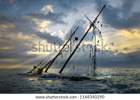 Shipwreck on beach. Boat stranded on the shore. Ship submerged by the waves on sunset.
