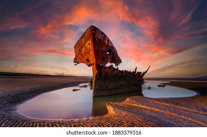 Shipwrecked off the coast of Ireland, An shipwreck or abandoned shipwreck,,boat Wreck Sunset light at the beach, Wrecked boat abandoned stand on beach or Shipwreck - Powered by Shutterstock