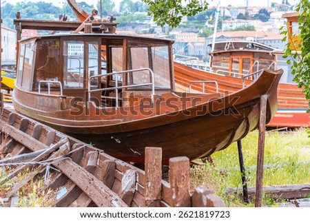 Shipwrecked and ruined wooden boats, such as Rabelos, and damaged vessel wood frames litter a coastline of the quaint port wine town of Vila Nova de Gaia, Portugal, on the coast of Douro River