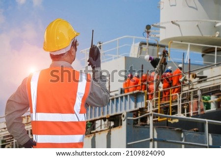 shipyard repairing and replacement of propeller of the ship in floating walkie- talkie or portable radio transceiver for communication in hand holding control worker order for maintenance.