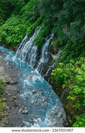 Shirahige Waterfall, mean White Beard, with deep cobalt blue hue Biei river flow beneath, Biei, Kamikawa Subprefecture, Hokkaido, Japan