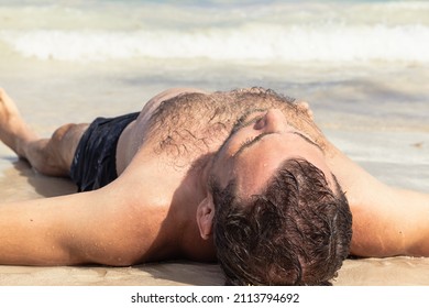 Shirtless Adult Man Lying Down On His Back On The Sand Beach, Relaxing, Sunbathing, Life Balance, Rest And Recovery Concept.