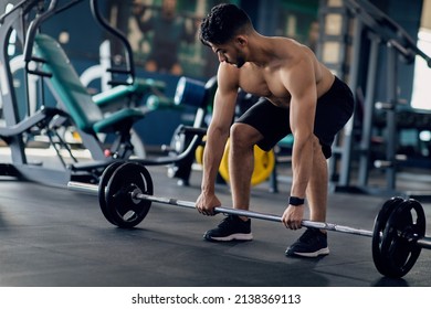 Shirtless Arab Man Making Deadlift Workout At Modern Gym Interior, Young Muscular Middle Eastern Guy Lifting Heavy Barbell While Training At Sport Club, Enjoying Bodybuilding Exercises, Closeup Shot - Shutterstock ID 2138369113