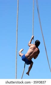 Shirtless athlete climbing up the rope - Shutterstock ID 3593837