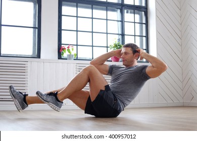 Shirtless Athletic Middle Age Man Doing Stomach Workouts On A Floor.