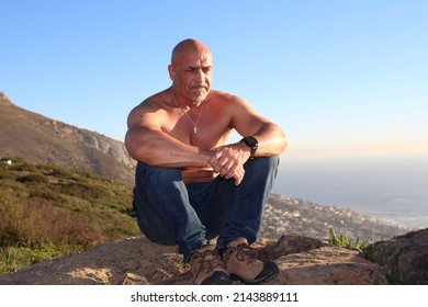 Shirtless Bald Muscle Man In Jeans Sitting On Signal Hill At Sunset With Contemplating Thoughts Thinking