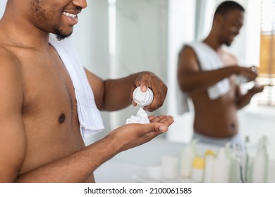 Shirtless Black Man Applying Shave Foam On Arm While Standind Near Mirror In Bathroom, Smiling African American Guy Preparing For Shaving, Making Morning Beauty Routine At Home, Selective Focus - Powered by Shutterstock