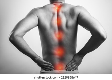 Shirtless Black And White Male Body Stretching His Back Suffering From Spinal Cord Inflammation. Red Highlighted Spot On Backache.