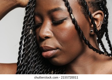 Shirtless Black Woman With Afro Pigtails Looking Downward Isolated Over Grey Background