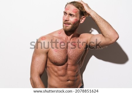 Shirtless blonde man with lipstick smudge posing on camera isolated over white background