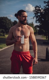 Shirtless Hipster Man Eating Protein Bar After Hard Workout