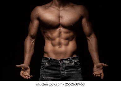 Shirtless male model showing muscular build with jeans in moody lighting - Powered by Shutterstock