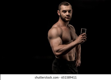 Shirtless Man Holding Glass Of Water In Hand Isolated On Black