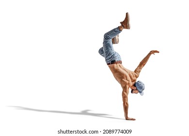 Shirtless man in jeans performing a one hand stand isolated on white background