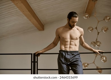 Shirtless man perched on staircase rail at home. - Powered by Shutterstock