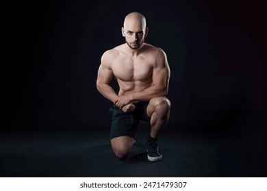 shirtless muscular Turkish man squats on the floor, gazing confidently at the camera. His strong physique and intense expression create a powerful and captivating image - Powered by Shutterstock