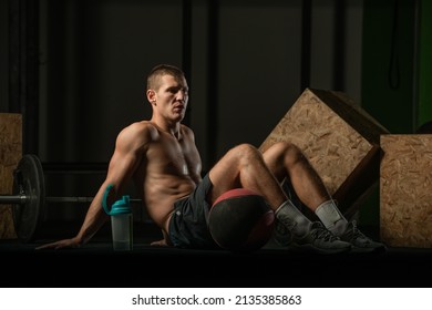 Shirtless Pro Athlete Doing Russian Twist Abs Workout. Close Up Photo Of A Fit Male Athlete Doing Indoor Training.