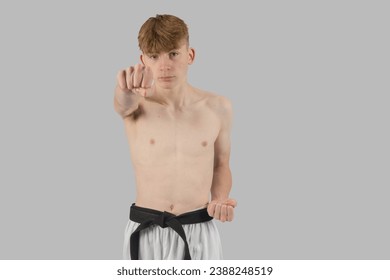 Shirtless teenage black belt martial artist punching head level - Powered by Shutterstock