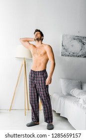 Shirtless Tired Man In Pajama Pants Standing With Headache In Morning