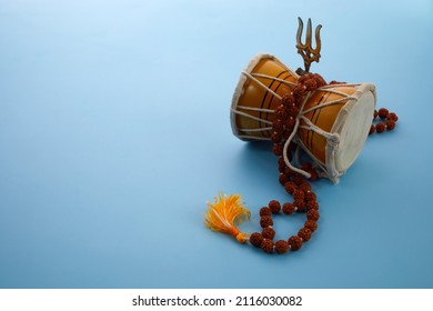 Shivaratri background with Shivas trident and Pellet Drum Damroo musical instrument . Hindu festival Maha Shivratri