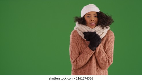 Shivering Young Black Woman In Winter Clothes Standing On Green Screen
