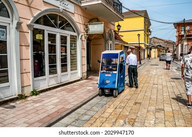 Shkoder, Albania - June 21, 2021: An Old Man And His Golf Car On The Rruga G'juhadol Pedestrian Street In Shkodra. Urban Lifestyle In An Albanian Old Town