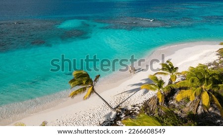 shoal bay east, Anguilla. Couple walking on the beach. Beautiful beach with turquoise sea. Crystalline waters of white sand, with plenty of shade from coconut trees. The best beach in the Caribbean.